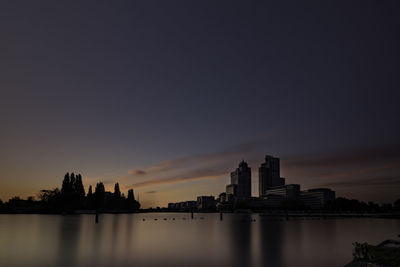 Silhouette buildings against sky during sunset