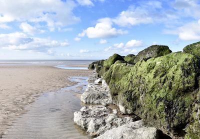 Rocks on beach against sky