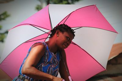 Low angle view of woman holding umbrella