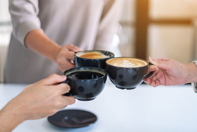 Midsection of man holding coffee cup