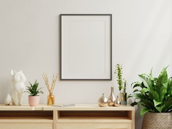 Potted plant on table against wall