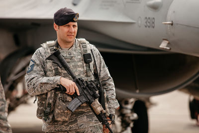 Portrait of man standing by airplane at bus