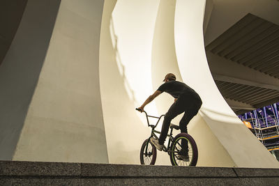 Man riding bicycle on staircase of building