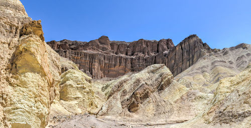 Rock formations on mountain against clear blue sky