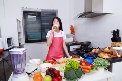 Woman standing by fruits at home