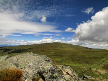 Scenic view of green landscape against cloudy sky