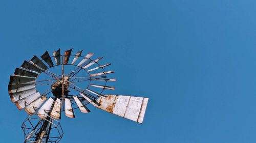 Low angle view of ferris wheel against blue sky