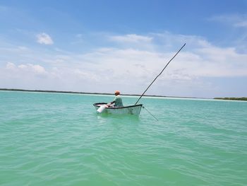 Man on boat in sea against sky