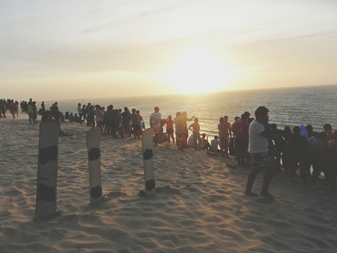 sea, beach, water, horizon over water, shore, sky, sunset, sand, scenics, large group of people, tranquil scene, beauty in nature, vacations, leisure activity, tranquility, lifestyles, nature, sun, person