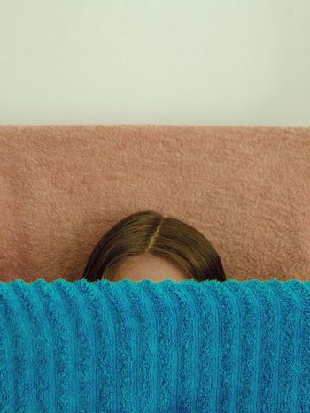 Cropped image of woman with fabric against wall