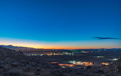 Illuminated cityscape against clear sky at night