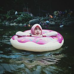 Portrait of young woman floating in swimming pool