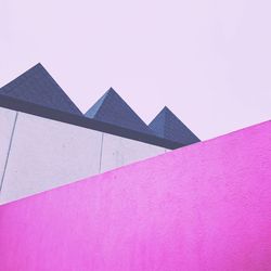 Low angle view of pink building against sky