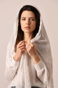 Portrait of young woman standing against white background