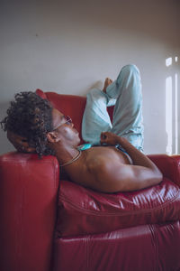 Side view of man lying on couch at home