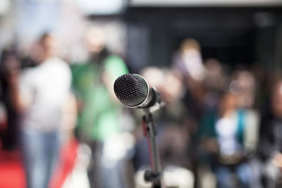 Close-up of microphone against crowd