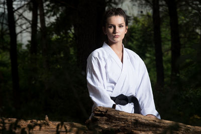 Portrait of young woman standing in forest