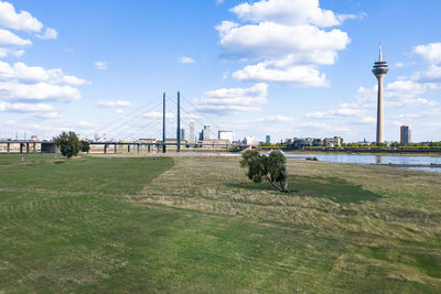 View of bridge and buildings against cloudy sky