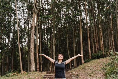 Woman breathing over beautiful eucalyptus forest landscape.nature, hiking and sustainability concept