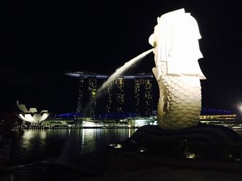 Illuminated city against sky at night