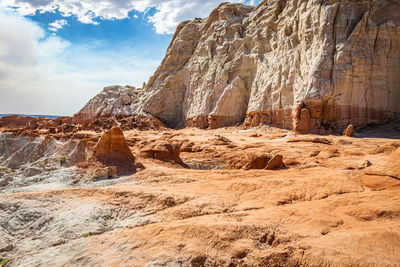 Rock formations on landscape against cloudy sky