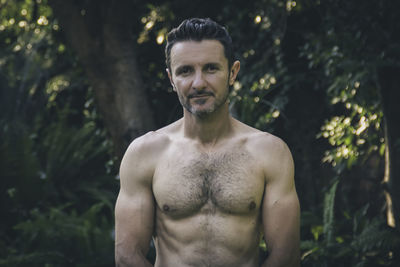 Attractive man in his forties, with his shirt off revealing his in form body. 