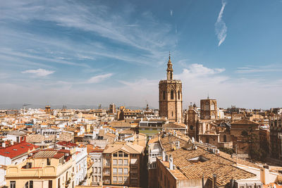 Buildings in city against cloudy sky