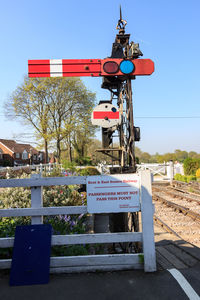 Information sign on road against clear blue sky