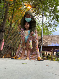 Full length of girl standing against trees