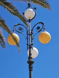 Low angle view of street light against blue sky