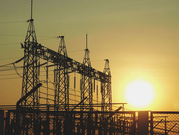 Low angle view of silhouette crane against sky during sunset