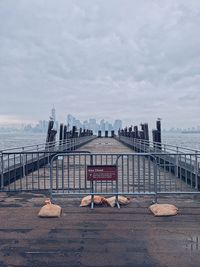 Bridge over river against cloudy sky