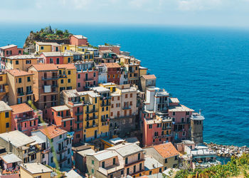 High angle view of townscape by sea against sky