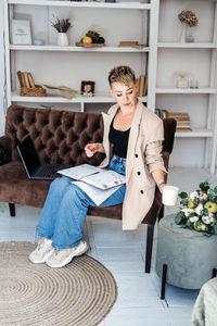 Modern hipster businesswoman with laptop and diary working at home office, planning, scheduling.