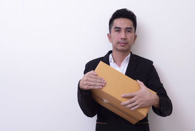 Portrait of young man standing against white background