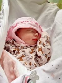 High angle view of baby girl sleeping on bed