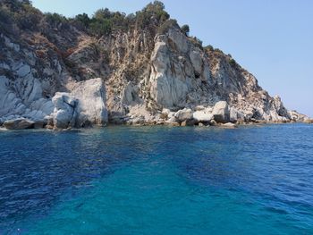 Scenic view of rock formation in sea against sky