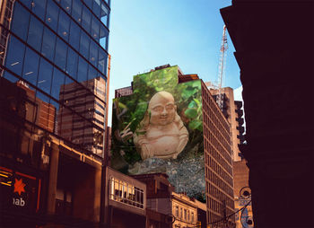 Low angle view of statue against buildings in city