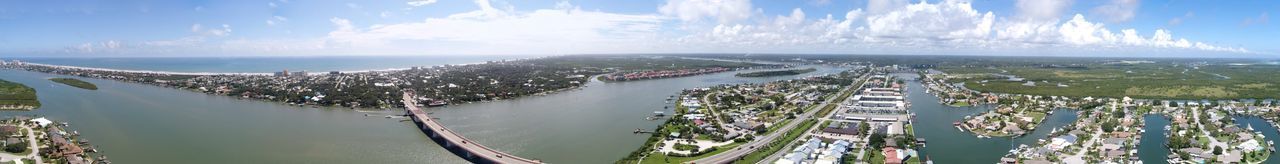 Panoramic shot of cityscape by sea against sky