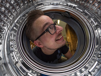 Smiling man looking in washing machine