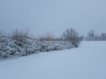 Snow covered landscape against clear sky