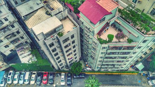 High angle view of cars parked on sidewalk by buildings in city