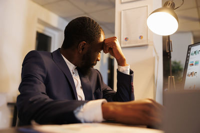 Side view of businessman using laptop at office