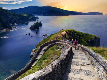 High angle view of women on sea by mountain against sky
