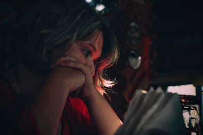 Close-up of thoughtful woman looking away while sitting at restaurant