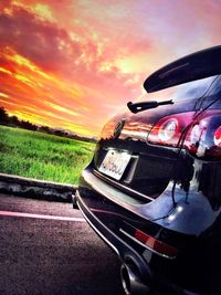 Close-up of car on road against sky during sunset