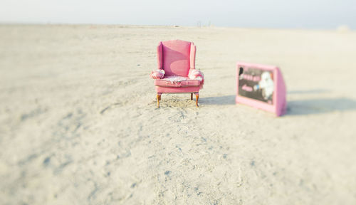 Deck chairs on beach against sky