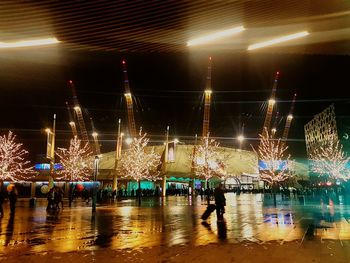 Crowd at illuminated city against sky at night