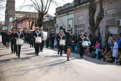 People on street against buildings in city