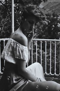 Young woman sitting on wall